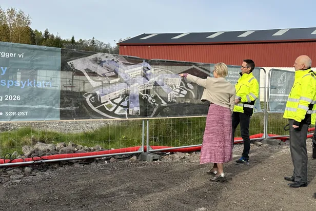 En gruppe mennesker som står ved siden av en vegg med et maleri