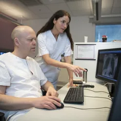 To sykehusansatte ser på radiologibilder på skjerm