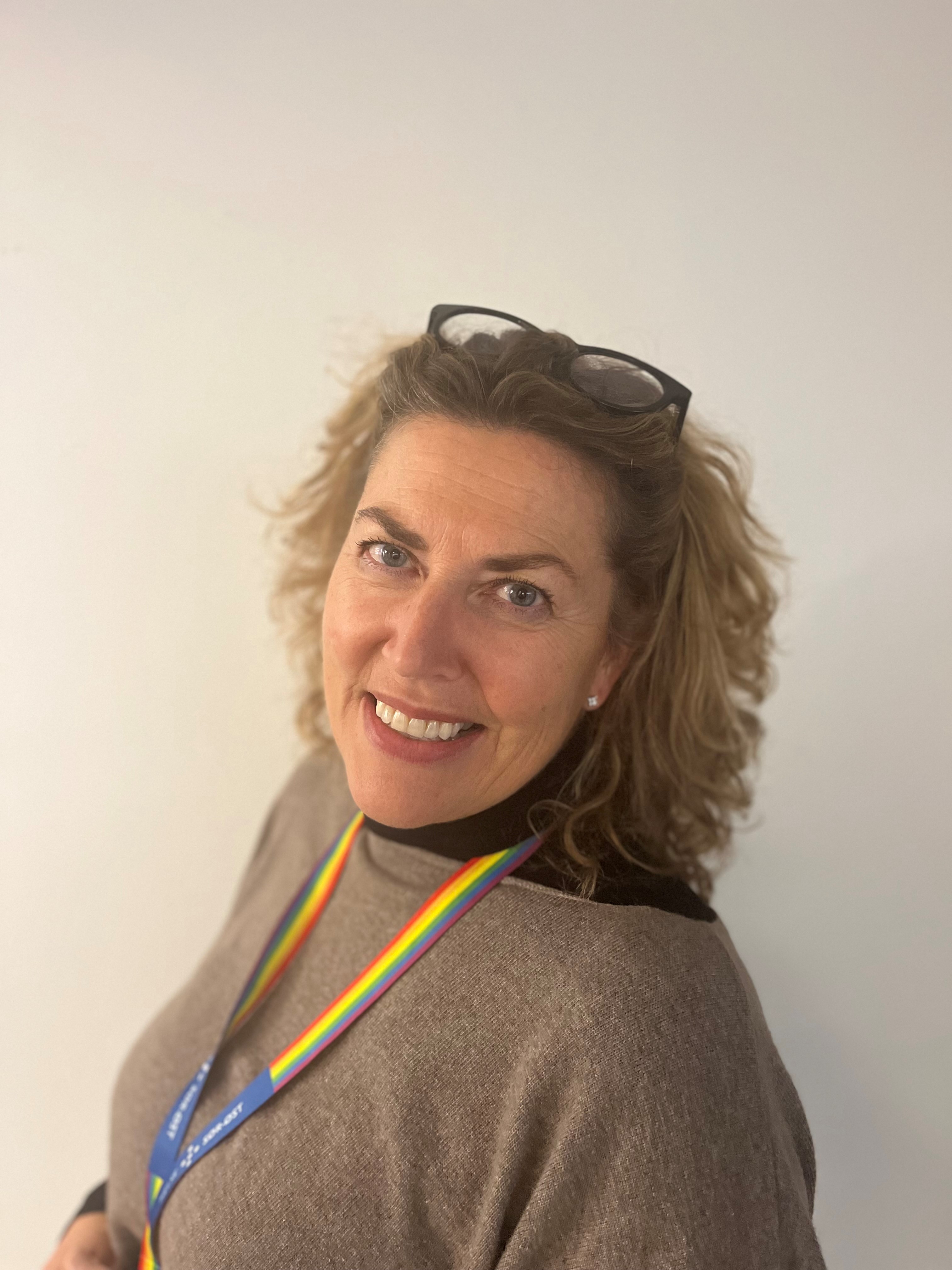 En kvinne som smiler til kameraet