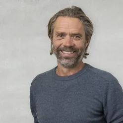 En mann som smiler til kameraet