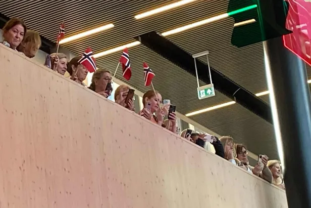 En gruppe mennesker som sitter på en vegg