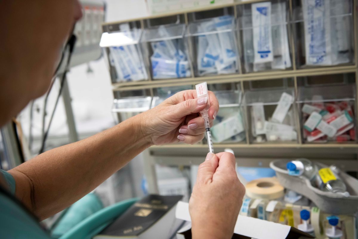 En person som tar en kanyle fra en hylle