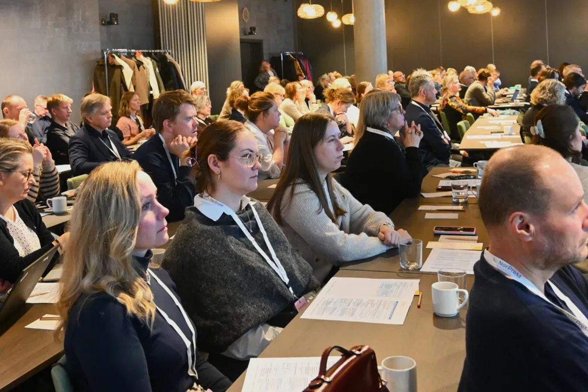En gruppe mennesker som sitter ved bord