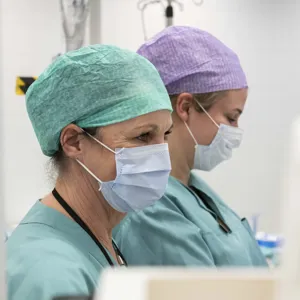 To ansatte med med opperasjonsluer og munnbind