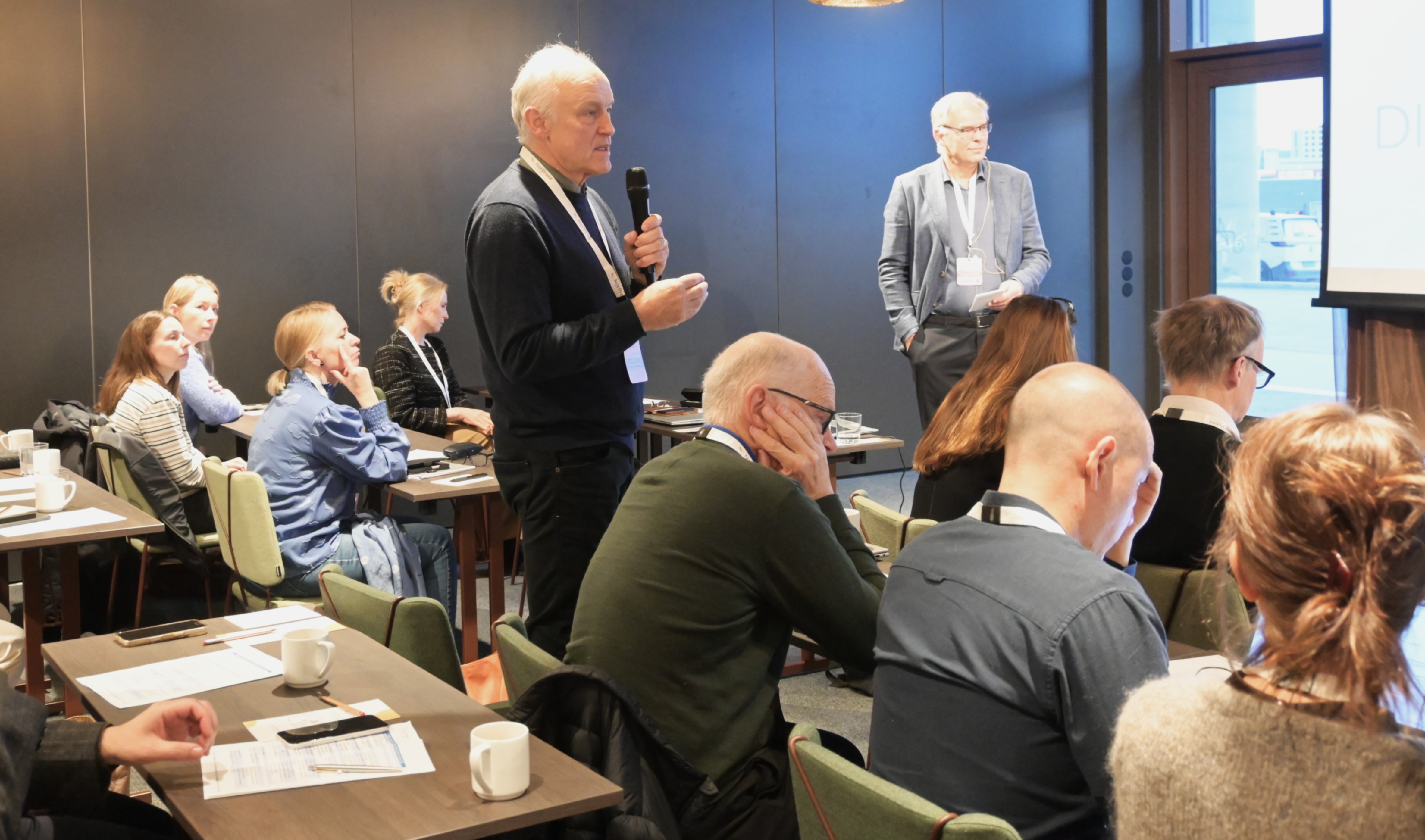 En person som snakker til en gruppe mennesker i et rom