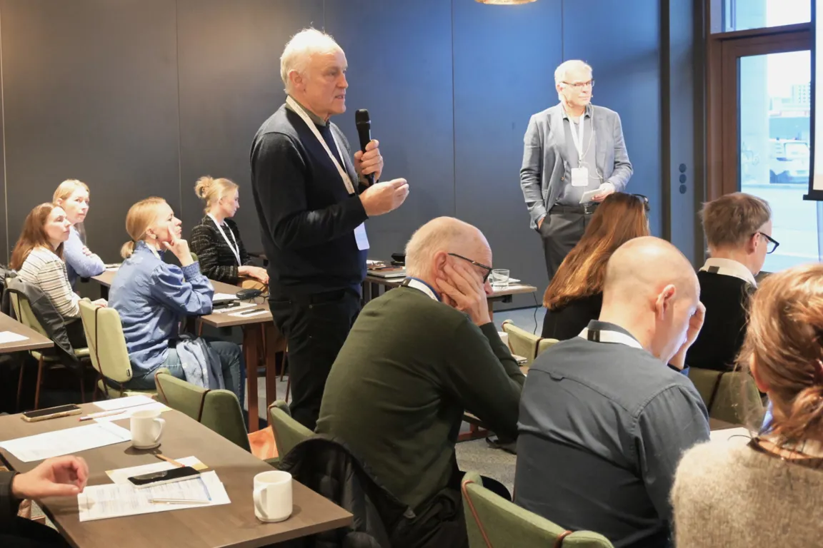 En person som snakker til en gruppe mennesker i et rom