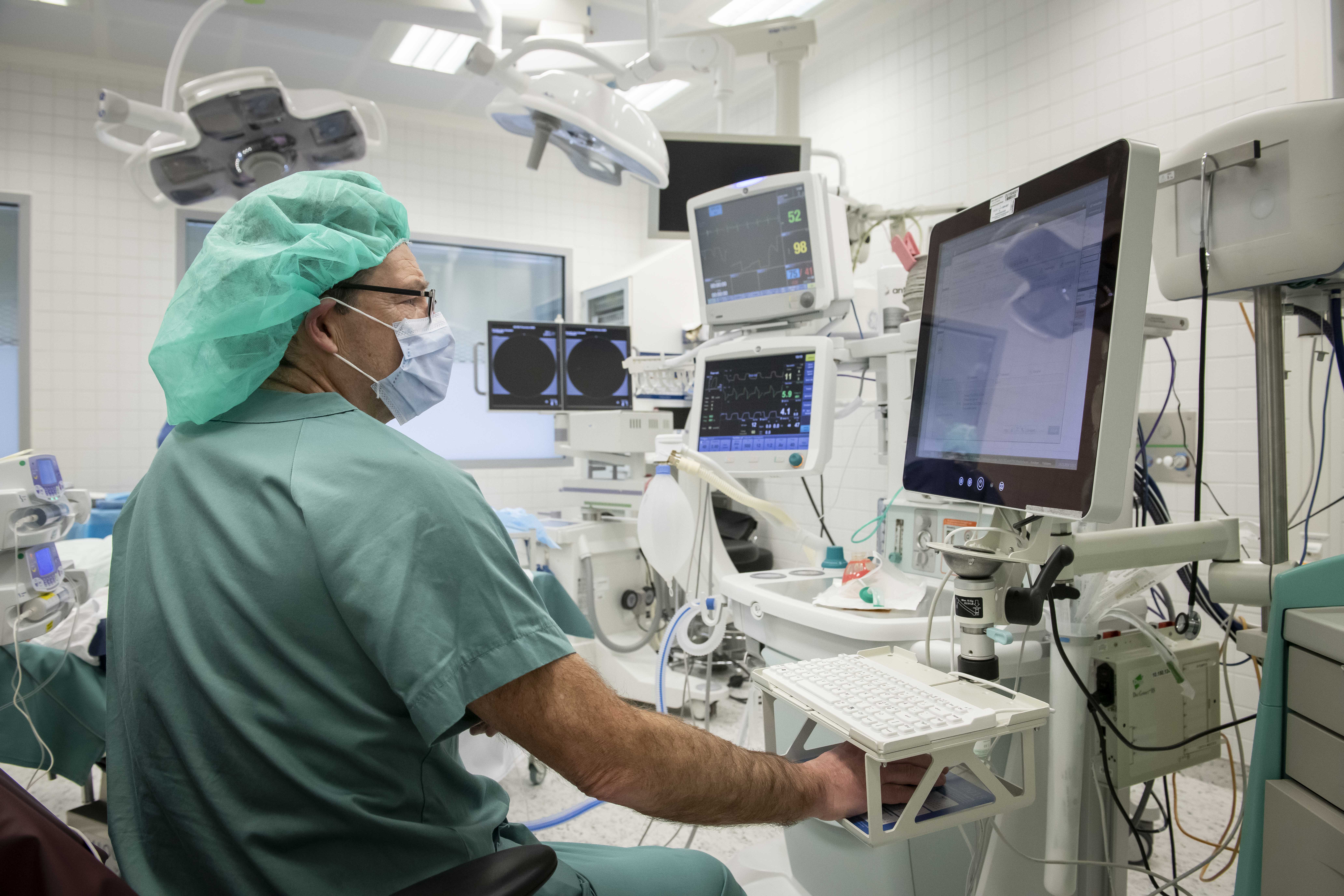 A man in a mask operating a computer