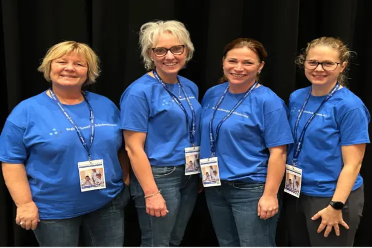 En gruppe kvinner iført blå skjorter