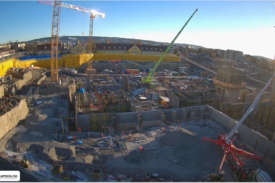 En byggeplass med kraner og bygninger