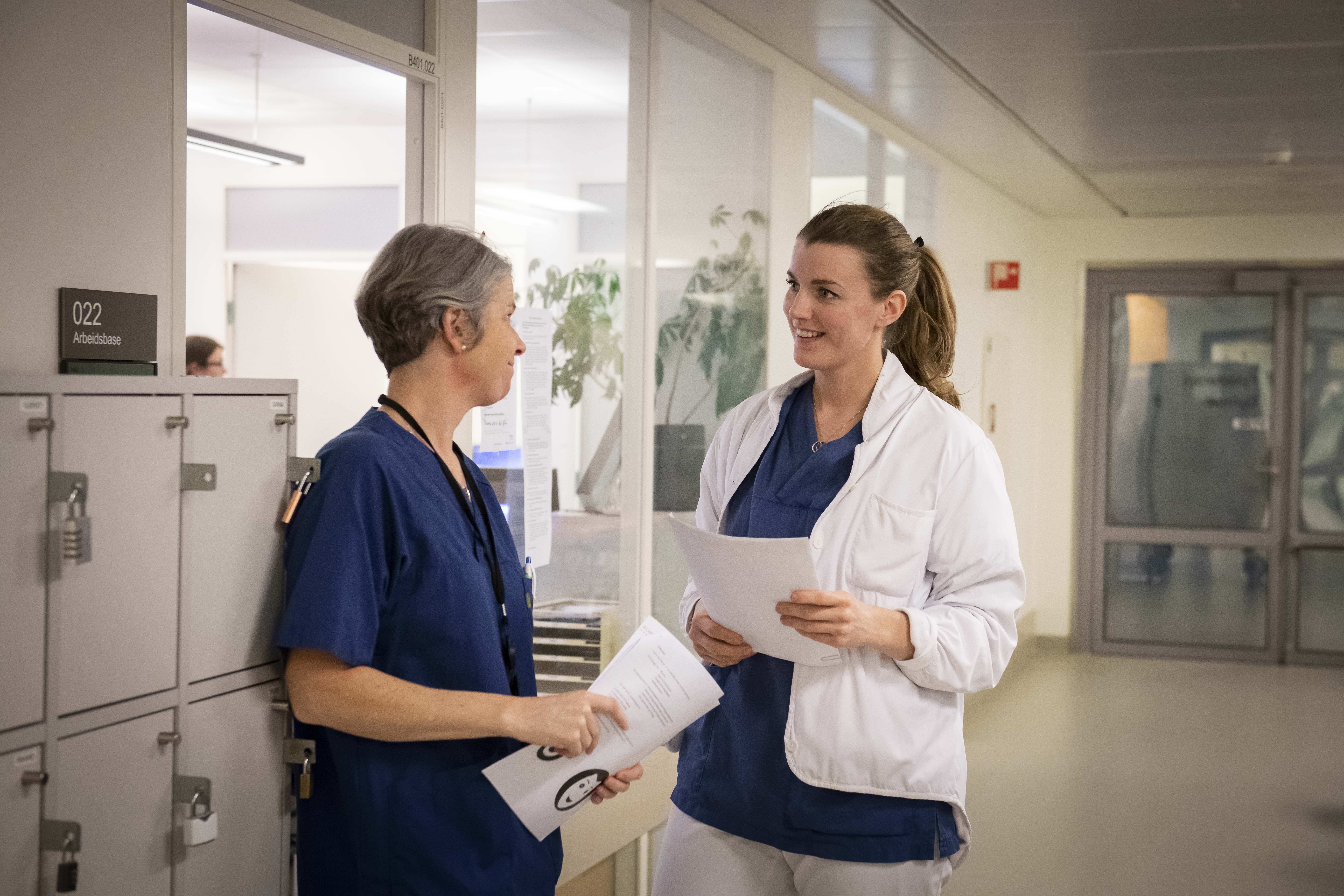 To kvinner snakker sammen i en korridor