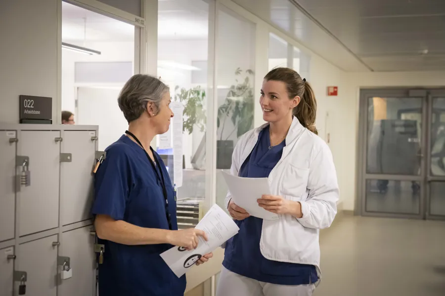To kvinner snakker sammen i en korridor