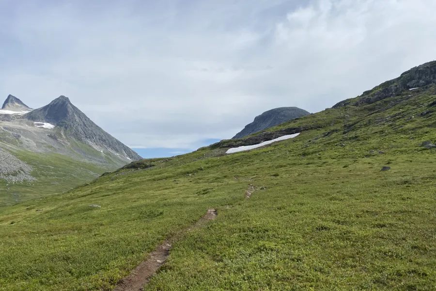 En grusvei i en gresskledd dal