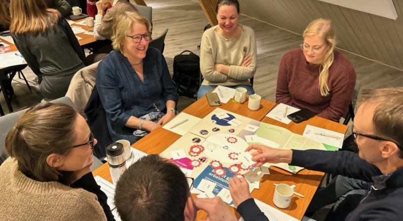 En gruppe mennesker som sitter rundt et bord og spiller brettspill