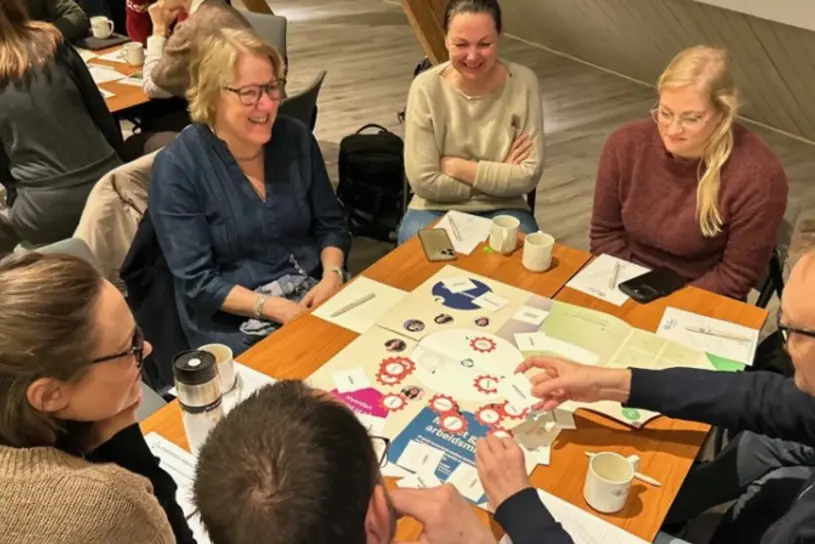 En gruppe mennesker som sitter rundt et bord og spiller brettspill